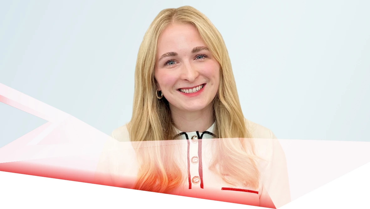 A person with long dark hair stands smiling in front of a light blue background with a red semi-transparent overlay below.