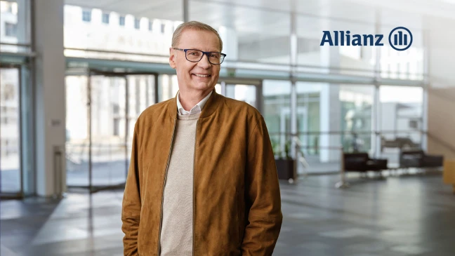 Person mit Brille in modernem Bürogebäude, daneben Allianz Logo