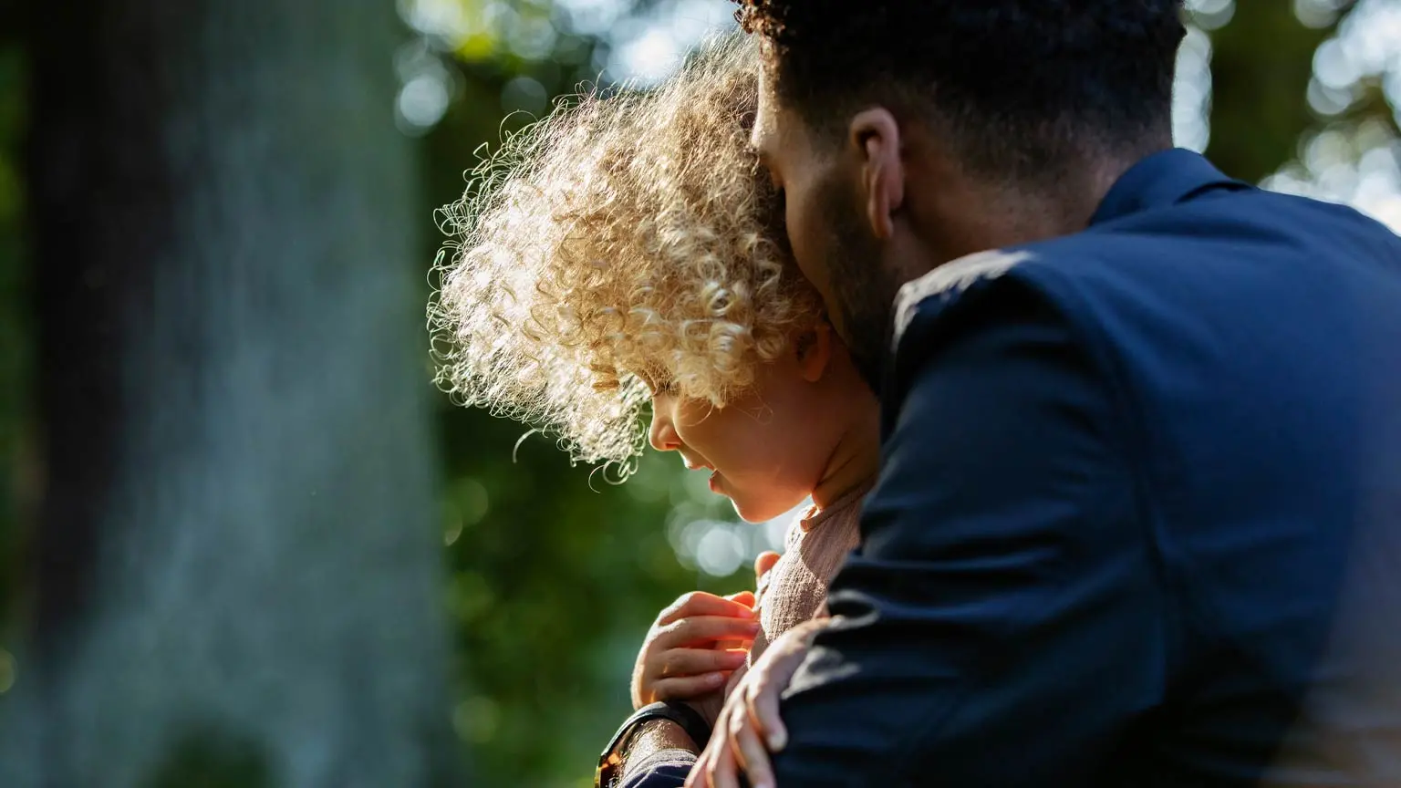 Mehrere nackte Beine und Füße über einem See, Personen sitzen auf einem Holzsteg bei Sonnenschein mit Landschaft im Hintergrund.