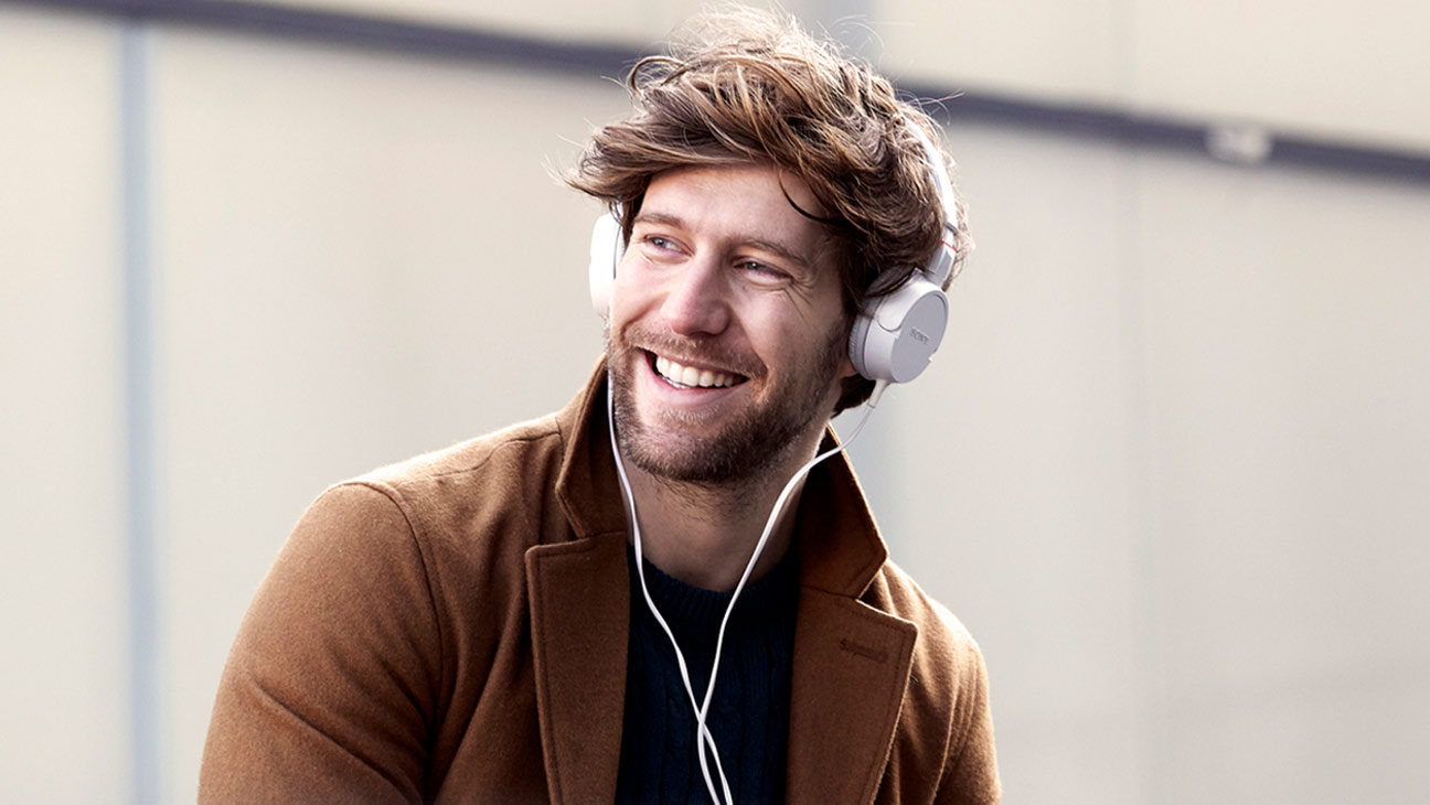 Mann mit Kopfhörern freut sich über das HVB PlusKonto