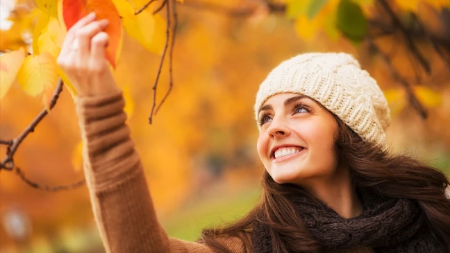 Lächelnde Frau im Herbstlaub