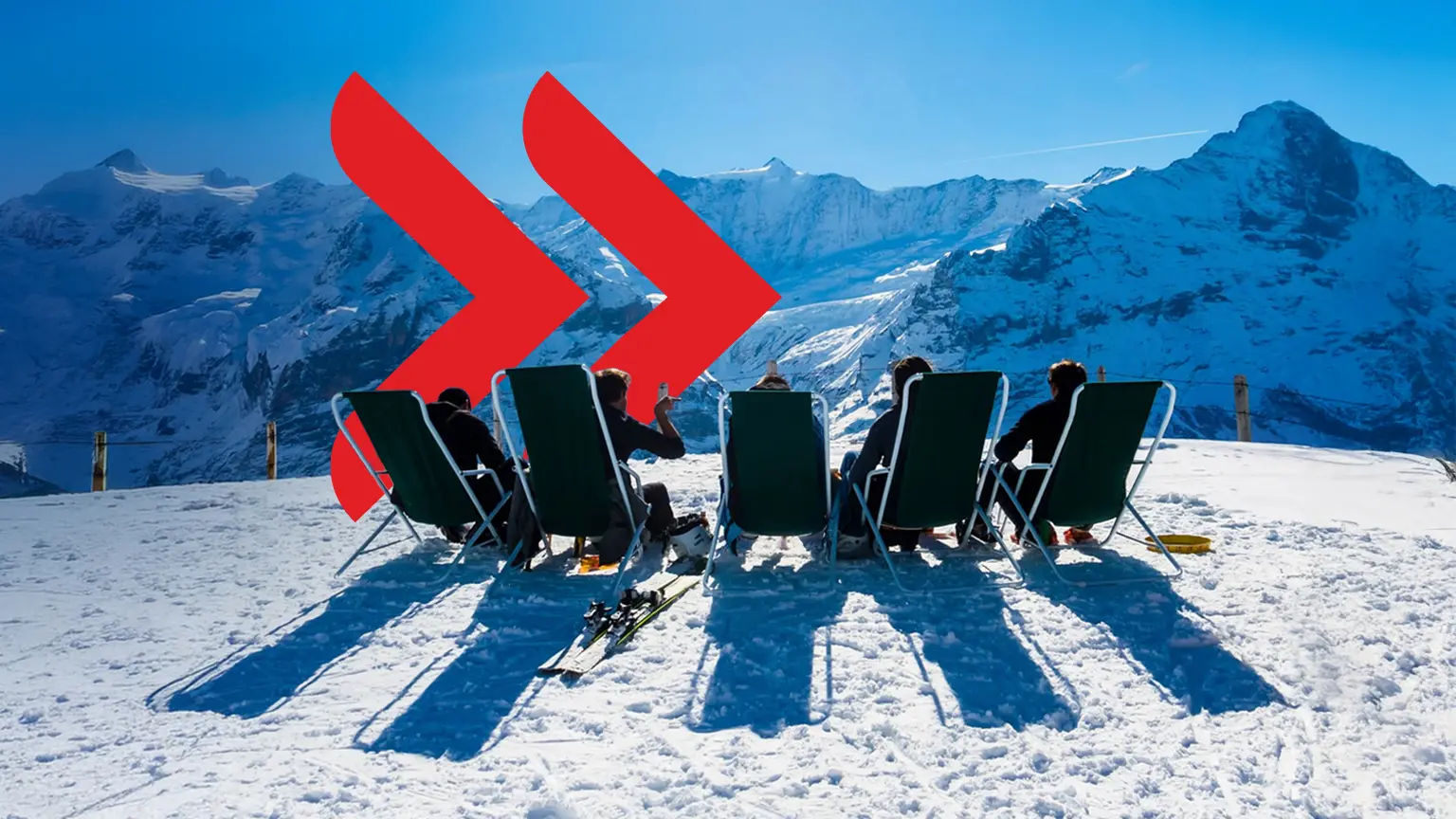 Mehrere Liegestühle mit Personen darauf im Winter auf dem Gipfel eines Berges im Schnee