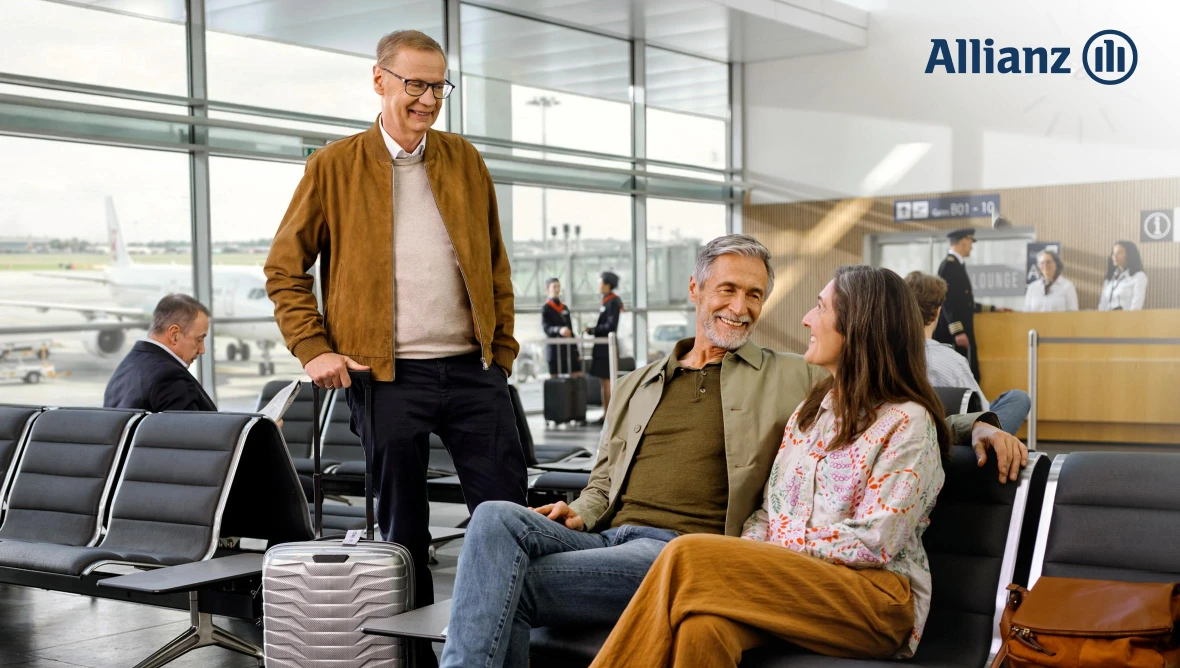 Drei Reisende warten im Flughafen-Gatebereich, sprechen miteinander; im Hintergrund Flugzeug, Personal und „Allianz“-Logo sichtbar.