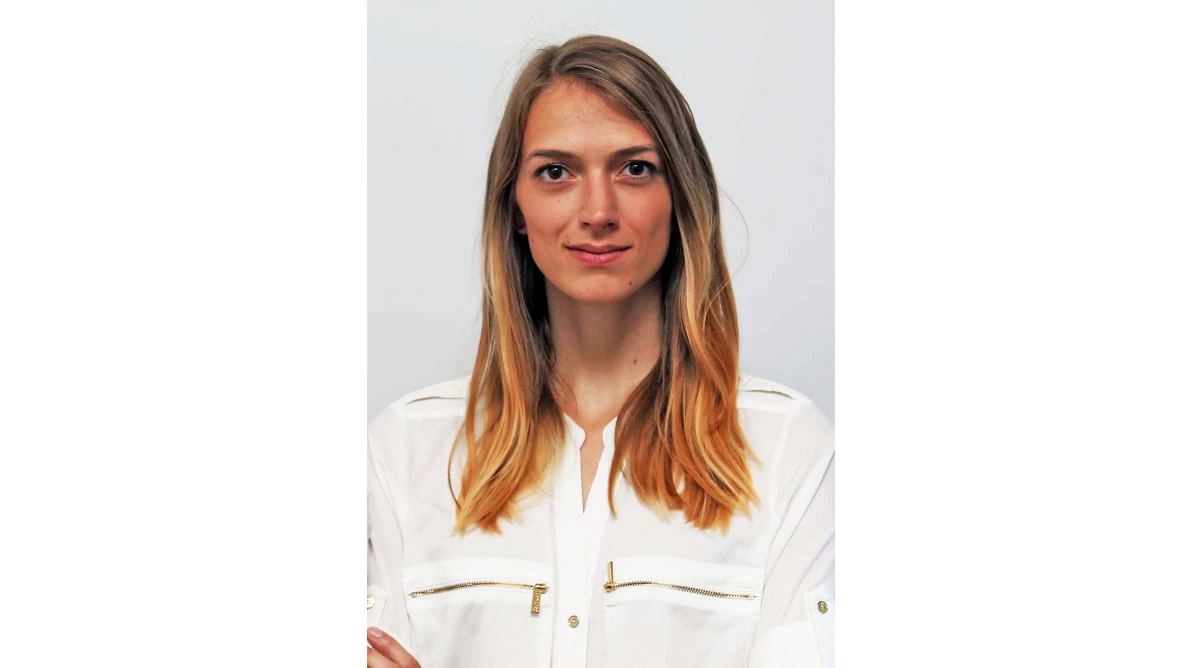 Frau mit langen glatten Haaren in Ombre-Stil trägt ein weißes Hemd mit goldfarbenen Reißverschlüssen vor hellem Hintergrund.