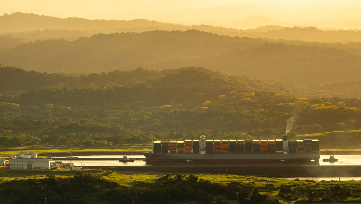 Containerschiff auf Flusslandschaft.